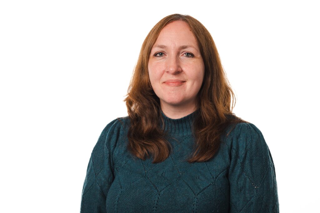 Headshot of Mind Tools editor, Lucy Bishop. She has brown hair and is wearing a dark green jumper.